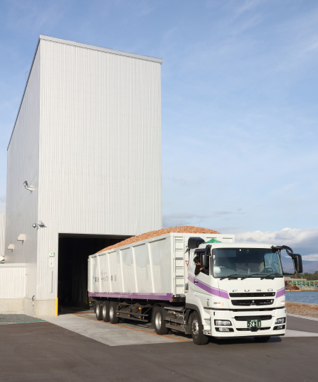 A truck fully loaded with wood chips heads for the hopper.