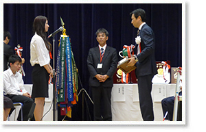 Erika Matsuda, winner of the first prize, receives the award from Kenji Shinmori, Executive Director of Sumitomo Group Public Affairs Committee.